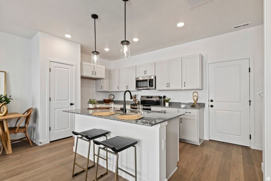 Move-in Ready! Discover your dream home in a brand-new gated community perfectly positioned near scenic parks, shopping, and favorite local dining spots. Just minutes from downtown Salt Lake City and the airport, this prime location truly has it all. Step inside to an inviting open-concept main level that feels instantly warm and welcoming-ideal for gatherings, celebrations, or quiet evenings at home. Enjoy everyday convenience with your modern kitchen located right off the garage-no more lugging groceries upstairs! At day's end, retreat to your spacious owner's suite featuring an impressive walk-in closet and a serene atmosphere designed for relaxation. A versatile loft provides extra space for work, play, or unwinding, while two additional bedrooms offer cozy comfort for family or guests. Every element has been thoughtfully designed-from premium finishes and energy-efficient features that help lower monthly costs to the confidence of an award-winning builder's warranty. This home isn't just move-in ready-it's ready to move you