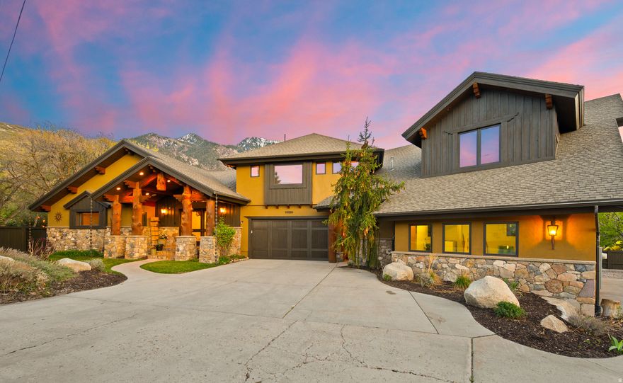 Rarely does a custom estate of this caliber hit the market on Sandy's coveted Dimple Dell corridor, and at a price point that rewards the right buyer. This 8,164 SF, 6 bed, 5.5 bath home sits on .68 private acres, built in 2013 as the builder's personal residence, no detail spared. Hand-etched aspen glass entry doors open into a hand peeled Doug fir log and timber frame with hand-scraped white oak floors on the main level and one of a kind Myrtle wood floors in the upper level. The chef's kitchen features Viking appliances, 48-inch range with griddle, copper farmhouse sink, and chiseled-edge granite. A 24-foot disappearing glass wall frames mountain views and connects the great room to covered patios for seamless indoor-outdoor living. Two primary suites: the main level offers a jetted tub, steam shower, and walk-in closet with laundry; the upper level sits beneath a timber-and-steel vaulted ceiling with sauna and custom glass shower, plus a versatile office/rec room with a bar and pool table. The finished walkout basement delivers a full second kitchen, rec room, heavily insulated wine cellar/cold storage or sound room, three guest bedrooms, and a grotto entrance. Outside is this property's magic, a natural mountain-fed pool for cold plunges, hot tub, waterfall, stream, and mature grounds with a large garden irrigated by three owned shares of Bell Canyon water. Six-bay garage, heated workshop, EV charging, RV/boat storage. Owned solar for water heating. All furnishings included and move-in ready. Minutes to Snowbird, Alta, and Big Cottonwood Canyon.