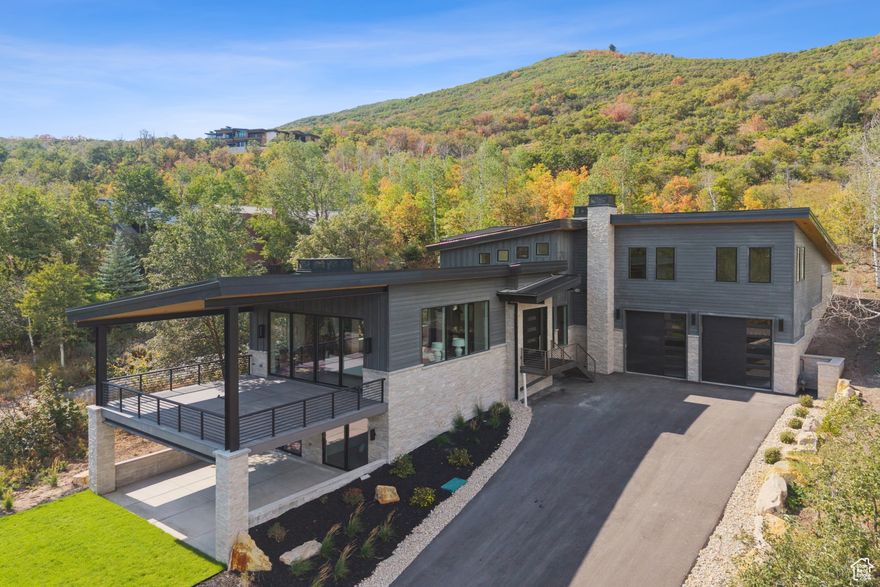 Rare and exquisite NEW custom home in Jeremy Ranch. Nestled in the wooded setting of Hidden Cove in Jeremy Ranch, this custom-built masterpiece combines striking mountain modern architecture with timeless craftsmanship. Designed with integrity and attention to every detail, the home showcases natural stone, warm wood accents, and a metal roof that blends seamlessly with its alpine surroundings. Inside, the open floorplan is anchored by a stunning great room that flows to a spacious deck overlooking mature trees and sweeping mountain views. The chef's kitchen is both functional and beautiful, featuring a large butler's pantry, an additional Sub-Zero refrigerator, and high-end finishes throughout, perfect for entertaining. The main-floor Primary Suite is a true retreat, complete with its own private patio for morning coffee or evening relaxation, a luxurious bathroom, built-in closet system, and dedicated washer and dryer. Upstairs, two well-appointed guest suites provide comfort and privacy, while a massive family room with an adjoining media area creates an almost soundproof space for movies, games, or gatherings. This level also includes another laundry area for convenience. The lower level is designed for wellness and recreation, offering walk-out bedrooms, a fitness room with space for a sauna and cold plunge, and a cozy reading/game nook with custom built-in bookshelves. A large laundry room, abundant storage, and radiant heated floors complete this level. For car enthusiasts and adventurers, the massive heated garage accommodates cars, RVs, sprinter van, boats, or any combination of toys your lifestyle demands. Every element of this residence reflects thoughtful planning, premium materials, and elevated living, making it a rare find in the coveted Jeremy Ranch community.