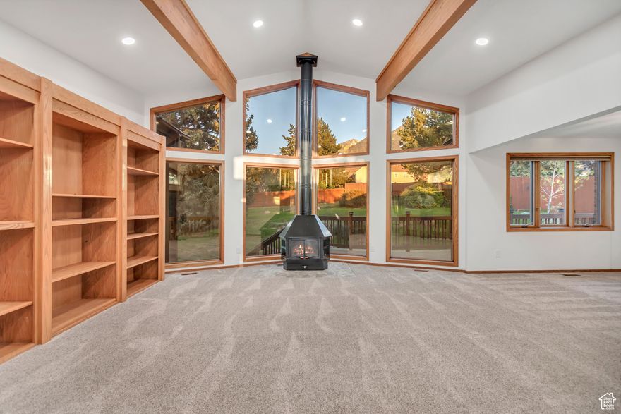 This beautiful Sandy rambler offers the perfect blend of comfort and style, set against a backdrop of breathtaking mountain views. Inside, you'll find gorgeous, vaulted ceilings with rustic wood beams, creating an open, airy atmosphere. The home has been freshly painted, and the carpet was replaced within the two years, adding a modern, well-maintained feel throughout.  Step outside and discover a freshly poured RV pad, ideal for all your outdoor adventures and parking needs.  The spacious basement is a standout feature, complete with a cozy wood-burning stove and a dedicated hot tub room  perfect for relaxing after a long day. Additional storage and a large shop/craft room complete with 240 V 20 amp receptacle for all your machining/wood shop needs.   Don't miss out on the opportunity to make this stunning home your own! Square footage figures are provided as a courtesy estimate only. Buyer is advised to obtain an independent measurement.