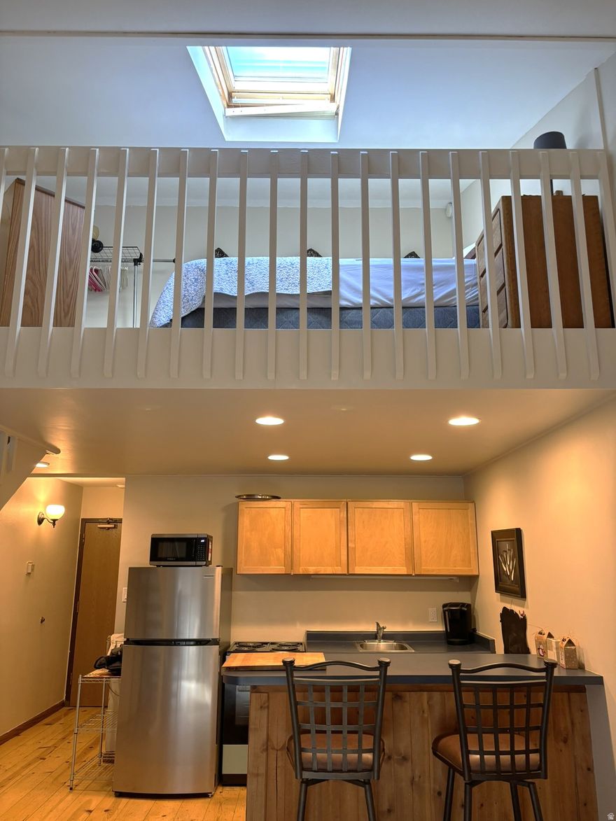 This condo has been updated to maximize both comfort and functionality. Vaulted ceilings, bright layout, and smart design add to the allure.  The loft adds separation between the living area and bedroom. Sold fully furnished and with new appliances such as a refrigerator, microwave and range, make this unit move-in ready and ideal for vacation use or nightly rentals.   Prospector Square condo HOA offers excellent amenities, including an outdoor swimming pool, year-round hot tub, laundry and proximity to the Silver Mountain Sports Club and Spa. Centrally located in the heart of Park City, this studio with a loft in Prospector Square offers the perfect blend of convenience, style, and investment potential. Situated on the free bus route, you and your guests can easily access Main Street, dining, world-class skiing, biking on the Rail Trail just outside your door, hiking, shopping, theaters, and Jordanelle Reservoir-no car needed.