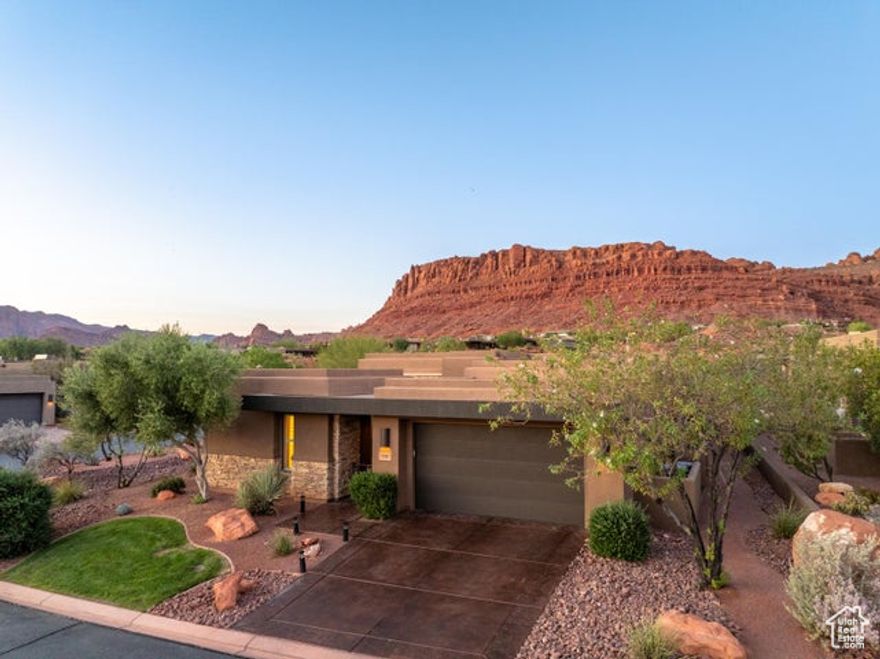 Experience refined desert living in this former Parade of Homes, perfectly positioned in the highly sought-after Escapes at Entrada community. With incredible, unobstructed panoramic views of Snow Canyon and the surrounding mountains, this residence is designed to capture the natural beauty of Southern Utah while offering the best in modern comfort. Featuring 4 spacious bedrooms and 4.5 bathrooms, including a detached casita ideal for guests or private retreats, every space has been thoughtfully designed with numerous upgrades and an elevated attention to detail. A spacious front courtyard welcomes you with warmth and privacy, setting the tone for the elegance within.  The 2.5-car garage provides ample room for vehicles and storage, while the heart of the home opens seamlessly to outdoor living.  An oasis for entertaining, the living and dining rooms feature sliding doors that create a natural flow to the outdoors, where guests can enjoy three distinct seating areas in the north-facing backyard. Complete with a built-in barbecue, cozy fire pit, and breathtaking views, this space was designed to make the most of Entrada's extraordinary setting.  Floor-to-ceiling windows and open living spaces highlight the surrounding red rock beauty, blending indoor elegance with outdoor serenity. This home truly combines luxury finishes, thoughtful design, and a one-of-a-kind locationoffering an unmatched lifestyle at Entrada.