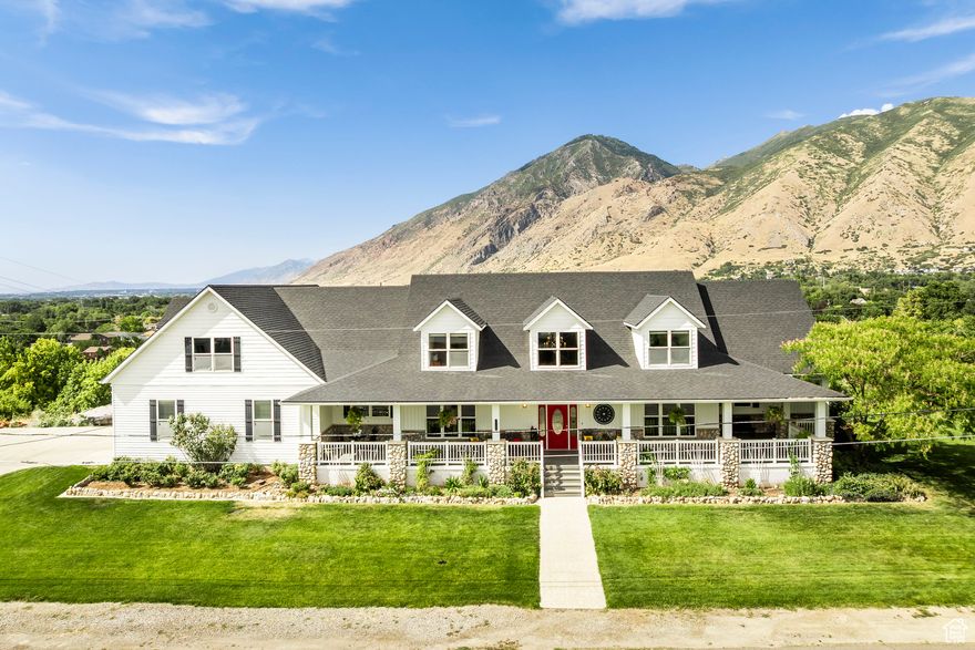 Set on 1.16 acres in Mapleton with mountain and valley views, this six-bedroom farmhouse offers the space, flexibility, and lifestyle buyers are looking for. The extra land along the east side of the home is included, opening the door to endless possibilities-build a detached garage, add a pool or pickleball courts, expand the lawn, or even create a future building lot. Expansive covered decks at the front and back invite year-round outdoor living, and the main-level primary suite opens directly to the back deck for a private retreat. Inside, the open-concept kitchen, dining, and family room provide a comfortable central gathering space, complemented by a separate front room that works well as a home office or formal living area. Upstairs there are five bedrooms, including a full apartment over the garage with a private exterior entrance, perfect for guests, rental income, or multi-generational living. The walk-out basement is unfinished and ready for customization, and a four-car garage offers ample parking and storage. The roof was replaced last year. This is a rare chance to own a home with room to grow in one of Mapleton's most desirable settings.