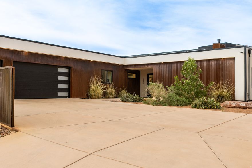SLICK, MODERN COMFORT. Set under the iconic Matterhorn, this contemporary beauty was meticulously designed to appease the sophisticated eye. Simple, yet elegant with seamless integration into the red rock viewscape with exceptional outdoor space. Offered with the fine furnishings, you will have the ease of moving straight into comfort. Twelve-foot ceilings throughout help enhance the architectural position of the home for maximum benefit of views. This newly constructed luxury home with superior style and superior function celebrates two master en-suites, an additional guest bedroom and bath, office, as well as an outstanding mudroom with laundry. The generous living space beckons natural light with a formal dining room, open kitchen featuring custom welded metal work, quality stainless steel appliances, quartz countertops, and island seating. Both en-suites grant dual sinks, lavish showers with glass doors, and ample closet space. Concrete floors throughout compliment the crisp, clean lines of the home and help with ease of maintenance. Slide into the hot tub on one of the covered back patios to soak in the red rock splendor. The attached 3-car garage will assist with keeping your vehicles cared for, with additional parking on the oversized concrete driveway. This home is perfect for your recreational life and your love of linear design. Located near Moab's Golf Club, this marvel is within walking distance to hiking & golfing- as well as easy access to world-class OHV trails.