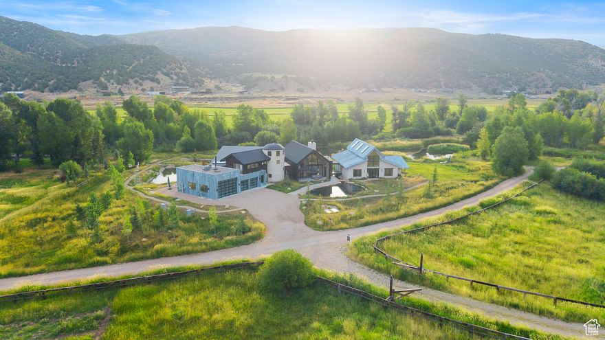 Stark Ranch is a one-of-a-kind riverside estate, where luxury meets nature along 450 feet of pristine Weber River frontage. Designed by renowned architect Rick Brighton, this architectural marvel spans over 21 acres, offering a rare combination of serene beauty, equestrian excellence, and outdoor adventure. Set against a backdrop of seven picturesque ponds and the Weber River, this property is perfect for fly fishing enthusiasts who can enjoy their own private waters, while an agroforestry plan brings sustainable homesteading potential to life. The ranch features not just a horse barn, but a state-of-the-art equestrian facility tailored for high-end horse owners. Complete with heated stables, a warming room with a fireplace, and extensive storage for gear, this is a dream come true for anyone passionate about the equestrian lifestyle. The home itself epitomizes luxury indoor-outdoor living, with oversized sliding doors that open to panoramic views of the river, valley, and surrounding mountains. Indoor planters and natural wood accents bring the outside in, while unique architectural features-such as the glass overpass with water flowing beneath it-enhance the home's serene, spa-like ambiance. The sunken living room offers a cozy yet grand space to relax, enhancing the home's natural elegance. A dedicated yoga room in the silo provides a peaceful retreat, perfect for re-centering amidst the tranquil surroundings. This legacy property offers something truly unique-exclusive water rights, pristine natural surroundings, close proximity to Park City and a lifestyle no one else can have. Thoughtfully designed wings ensure privacy for both guests and residents, while amenities like the outdoor spa and two-story sauna invite relaxation after a day spent exploring the expansive property. Stark Ranch is not just a residence; it's a rare opportunity to own an unparalleled piece of natural beauty and craftsmanship.