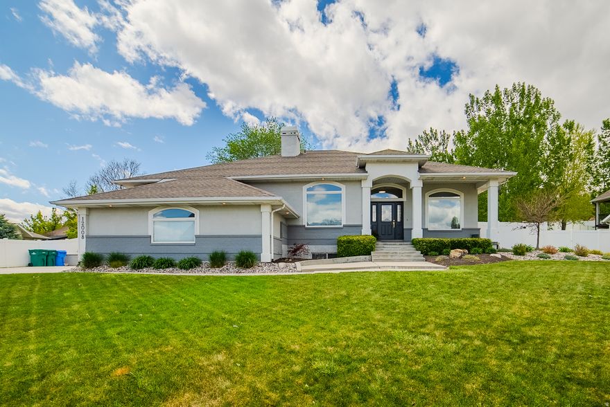 Tucked away in the serene river bottom at the coveted tri-border of Riverton, South Jordan, and Draper, 12008 Reeves Lane is one of those rare properties that simply has it all - and then some. This stunning east-facing custom home greets you every morning with breathtaking, unobstructed views of the Wasatch Front looking directly up at majestic Lone Peak, while direct access to the Jordan River Parkway sits right at your doorstep. Don't let the peaceful, tucked-away setting fool you - freeway access via 11400 South and 12600 South is just minutes away, and Silicon Slopes is less than a 10-minute drive, making this one of the most uniquely positioned homes on the market. From the moment you arrive, the custom craftsmanship is undeniable inside and out - spanning 4,890 square feet of thoughtfully renovated living space, the main level impresses with soaring 10-foot ceilings, beautiful hardwood floors, and a seamless open flow from the entry through the dining area into the stunning great room. The chef's kitchen is a showstopper with white shaker cabinetry, a herringbone tile backsplash, a generous quartz island, gold pendant lighting, and premium stainless appliances, all opening to the living room anchored by a shiplap fireplace with walnut mantle and a wall of oversized windows framing the lush backyard. The main-floor primary suite is a true sanctuary - a beautiful door opens to the backyard, and the spa-inspired en suite stuns with dual granite vanities, a floor-to-ceiling walk-in tile shower with glass enclosure, and a beautiful tray ceiling with arched detail. Downstairs, the fully self-contained mother-in-law apartment elevates this home to another level entirely, complete with its own full kitchen, stainless appliances, eat-in dining, and a spacious en suite bedroom with walk-in closet and dedicated sitting area - ideal for extended family, guests, or multigenerational living. Custom-built, beautifully renovated, and perfectly positioned in one of the most desirable and tranquil settings along the Wasatch Front - this is the one you've been waiting for. Don't miss it. Preferred Lender incentive reach out to Taylor for more information.