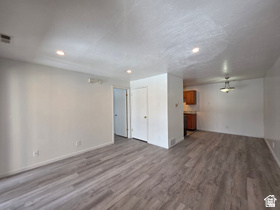 Open concept living area featuring wood-finish flooring, recessed lighting, and a neutral color palette