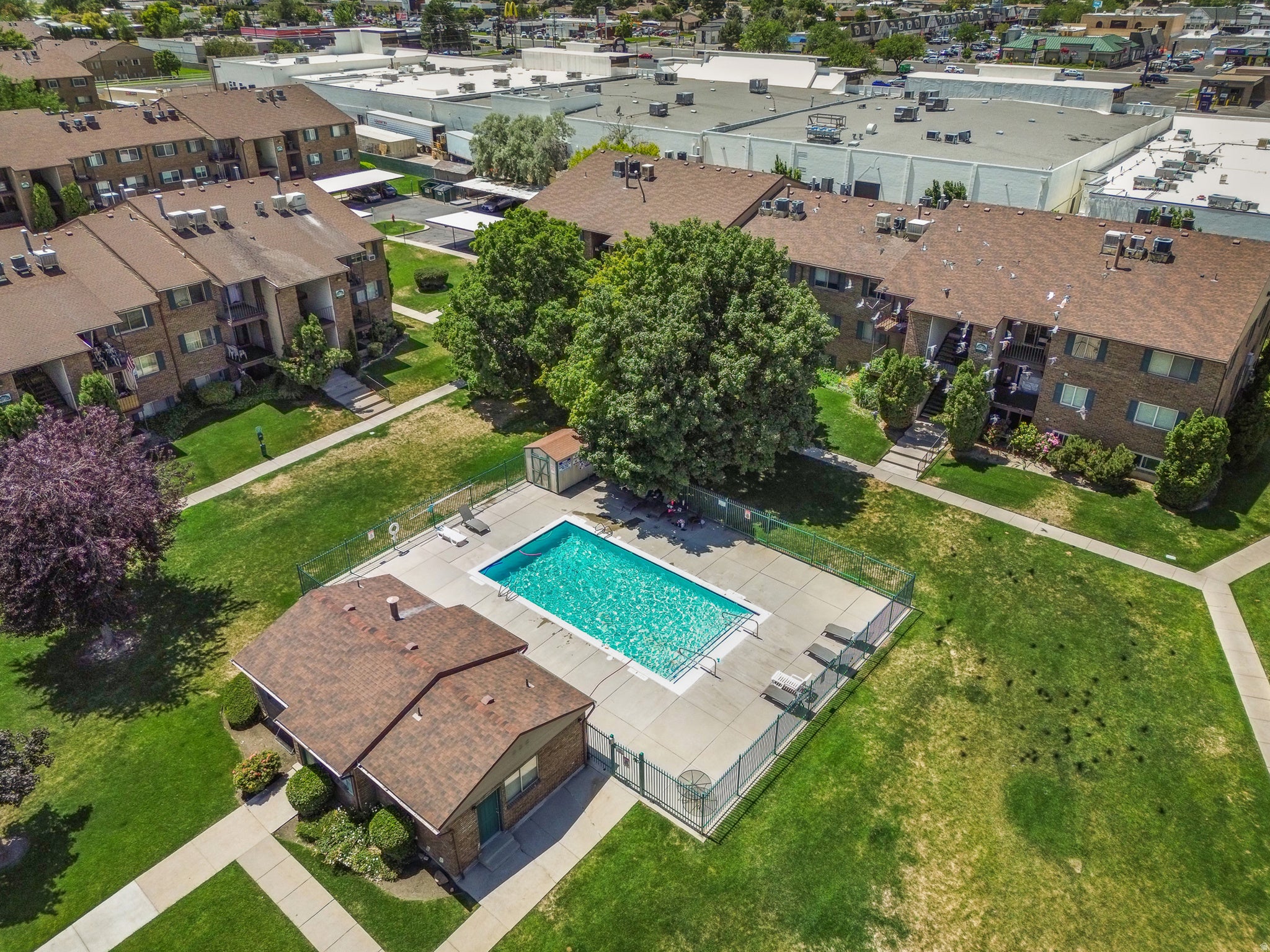 Community swimming pool with surrounding concrete patio and fenced enclosure