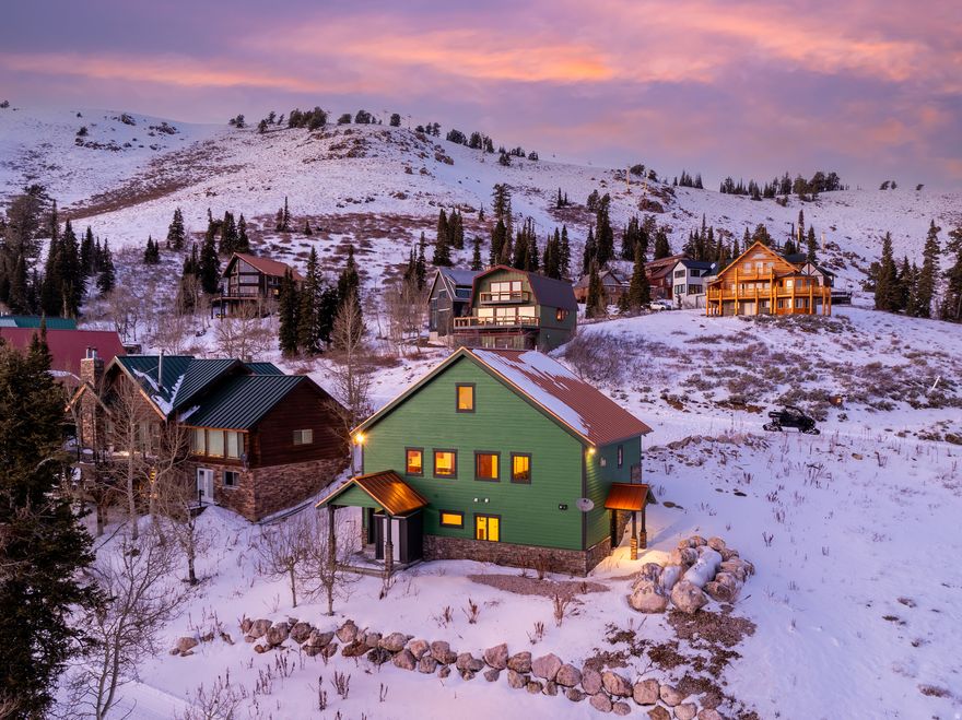 Aspire to do life in this vortex - where adventure, community, and alpine beauty meet at Powder Mountain. Discover mountain living at its finest in this stunning 4-bedroom, 5-bath retreat located on world-renowned Powder Mountain. Offering true ski-in, ski-out access, this home provides unmatched convenience for outdoor enthusiasts looking to hit the slopes at a moment's notice. After an exhilarating day of skiing, relax and unwind in the aprs-ski sauna, completing your perfect mountain experience. Thoughtfully designed to capture panoramic alpine views, this home blends modern comfort with rustic elegance. The windows, while not expansive, are purposefully sized to maximize energy efficiency and preserve the view plane, offering just the right balance of natural light and privacy. A spacious downstairs studio offers flexibility for guests, a home office, or a quiet retreat. The main living areas are brightened by abundant light while maintaining a cozy, intimate atmosphere. The stone fireplace in the great room provides a warm and inviting space for family and friends to gather after a day in the mountains. The functional kitchen flows seamlessly into the dining and living areas, offering ample storage and workspace for cooking and entertaining. The primary suite is a true sanctuary, featuring sweeping mountain vistas and a luxurious, spa-inspired bathroom. Multiple living spaces ensure there's always a spot to relax, work remotely, or host loved ones. With direct access to world-class skiing, hiking, biking, and year-round mountain adventure right outside your door, this home offers unparalleled access to all that Powder Mountain has to offer. Additional highlights include durable flooring, generous gear storage, thoughtful lighting, and an inviting mountain-lodge feel. Whether you're seeking a full-time residence or a luxurious alpine getaway, this beautifully constructed home delivers comfort, style, and a prime location at the resort. All property information, boundaries and documents to be verified by buyer.