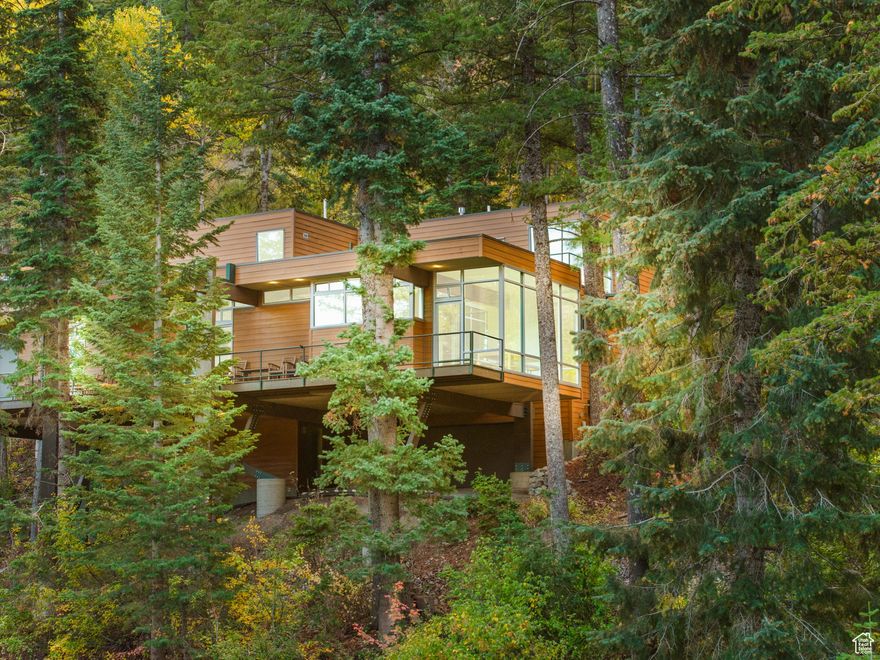 Welcome to Hummingbird Haus! A sanctuary of light, serenity, and flight above Sundance Mountain Resort. In folklore, the hummingbird is a sacred messenger - a symbol of joy, resilience, and the quiet miracle that lives within nature. Hummingbird Haus was designed in this spirit: graceful, luminous, and alive with the brilliance of the mountain. Tucked deep within Sundance's only gated enclave and nestled against the enchanted Black Forest, this architectural jewel is a rare offering. A ski-in/ski-out retreat, Hummingbird Haus offers direct access to Stewart Falls and the slopes of Sundance Resort, inviting you to glide effortlessly between alpine adventure and peaceful retreat. Crafted by legendary architect Frank Ferguson, co-founder of FFKR, this four-bedroom, four-and-a-half-bath residence draws from the refined principles of the International Style, made famous by Mies van der Rohe. Like the hummingbird in flight - weightless and precise - the home's minimalist form is a study in light, balance, and space. Vast floor-to-ceiling glass panels immerse the interior in golden mountain light, while framing snow-dusted pines, summer wildflowers, and the ever-changing dance of the seasons. Step inside to find an interior as elegant as it is inviting. Warm beechwood floors echo the forest outside, while a sunlit kitchen and hearth-wrapped library alcove call for slow mornings and long evenings. The home's soul lies in its quiet intimacy: modern, but never cold; sophisticated, yet endlessly welcoming. Whether creating in the dedicated studio/office, or wandering into the world-class amenities of Sundance: The Owl Bar, Tree Room, Summer Theatre, or the Bluebird Caf concert series. You'll find this isn't just a home. It's a habitat for wonder. A haven for stillness. A perch above the ordinary. Hummingbird Haus isn't just a residence, it's a retreat into the rhythm of the wild. Come home to a place where beauty hovers in stillness, and every window opens to possibility.  Square footage figures are provided as a courtesy estimate only.  Buyer is advised to obtain an independent measurement.