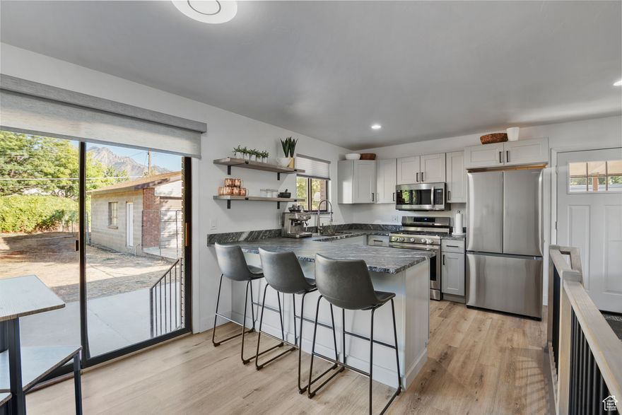 The curb appeal of this Midcentury Modern brick home sets the stage, but the true magic happens inside this magazine-worthy Millcreek residence, packed with upgrades and move-in ready! Step into this simply impeccable completely open,  professionally remodeled home featuring high-end Luxury Vinyl Tile floors, bottom up cordless cellular shades, a brand new open kitchen with new cabinetry, marble countertops and stainless appliances! New stair railing handsomely accents the main floor. Simply impeccable!  Entertaining easily spills onto an ample patio with breathtaking Mt Olympus views in a generous backyard awaiting the new owner to choose and finish the xeriscape, or complete auto sprinkler system for landscape of your choice!!! Oversized two car garage with tons of storage!!! Downstairs expands your living space with a modern open family room boasting a second fireplace, two additional bedrooms and a bathroom.  An unexpected exciting life change forces the surrender of this forever home and quality remodel completely ready for new lucky owners. Square footage figures are provided as a courtesy estimate only. Buyer is advised to obtain an independent measurement.