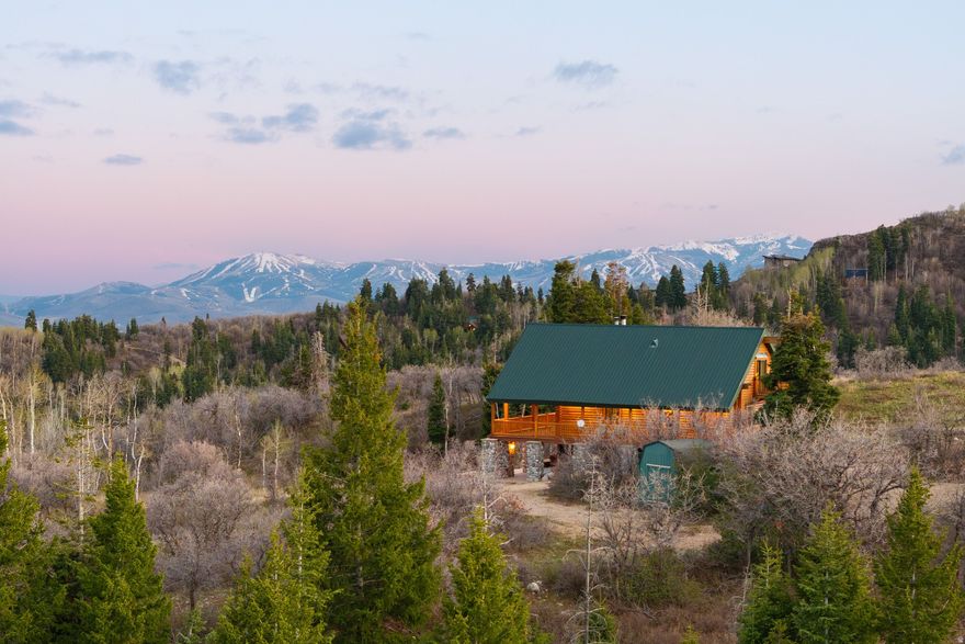 Set on over 5 private acres in Tollgate Canyon, this log home offers space, privacy, and easy access to Park City. Just 25 minutes to town and 50 minutes to Salt Lake City International Airport, it's an ideal fit for buyers looking to enjoy a mountain setting without giving up convenience or proximity to three major ski resorts.  South east facing with excellent sun exposure, the home is filled with natural light and captures expansive views of the Uinta Mountains and Deer Valley. With 4 bedrooms plus a large loft, there's flexibility for full time living, a second home, or hosting friends and family for weekend getaways.  This is an ideal property for those who value usable acreage, quiet surroundings, and year round recreation. Wildlife is common, with frequent sightings of moose and elk, and the wraparound covered porch creates a functional outdoor living space to take in the views from sunrise to sunset. Unwind after a day on the trails or slopes by relaxing in the brand new hot tub.   This is a wonderful opportunity to own a well cared for home on acreage in close proximity to Park City. Well suited for buyers seeking a mountain lifestyle with space, views, and access.