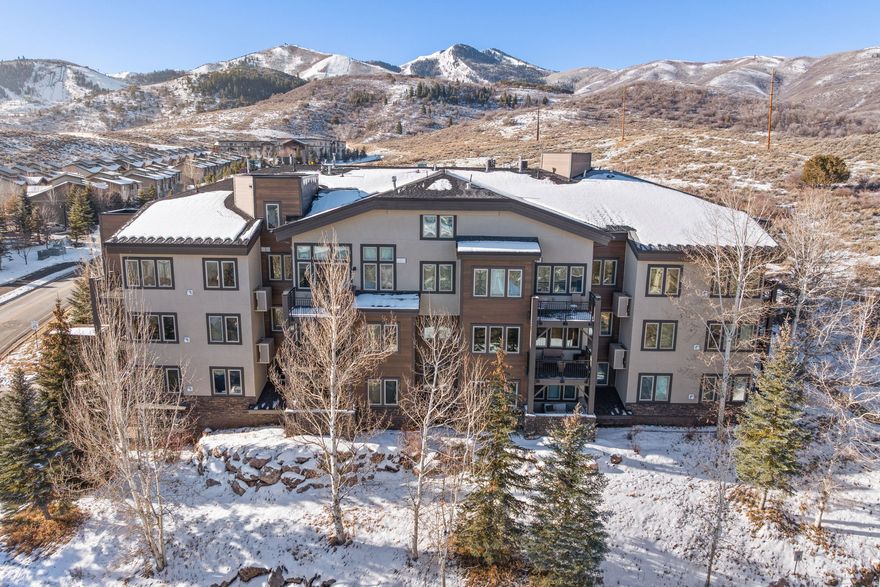 Perched to capture sweeping vistas, this 1-bedroom, 1.5-bath residence offers some of the most spectacular views in the community-stretching across the mountains, Olympic Park, and the surrounding trail system. The interior is defined by a light-filled, open layout where a cozy gas fireplace serves as the heart of the home, while a private covered deck invites you to step outside and soak in the scenery.  The thoughtfully designed kitchen features warm wood cabinetry, a gas stove, and a functional peninsula that flows seamlessly into the living space. For privacy, the bedroom includes a full ensuite bath, complemented by a convenient half-bath for guests and an in-unit washer and dryer. Enjoy elevator access, a dedicated space in the heated garage, and a large private storage closet-perfect for skis, bikes, and outdoor gear.  The community has recently undergone extensive exterior renovations, including new windows, roofs, and decks.  Take advantage of the clubhouse, pool, hot tub, fitness center, and direct trail access. Located in the heart of Kimball Junction, you are steps away from premier dining, shopping, and the free Park City bus route. With world-class ski resorts and Historic Main Street just minutes away, and a short 35-minute commute to SLC International Airport, this pet-friendly unit is the ultimate primary residence or mountain getaway.