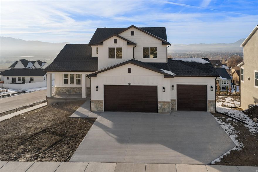 Perched on the east bench in Smithfield Ridges, this brand-new home was designed to capture sweeping views of Cache Valley from nearly every room. The open main floor features a dramatic two-story great room with a full wall of windows, warm LVP flooring, and a cozy fireplace that anchors the space. Just off the great room, a covered view deck invites you to relax and watch the sunsets. The gourmet kitchen offers rich wood custom cabinets, quartz countertops, a large island, stainless steel vent hood with pot filler, and an impressive walk-in pantry with countertop/appliance space. A convenient mudroom keeps everything organized as you come in from the 3-car garage. On the main floor, the primary suite enjoys tray ceilings, big view windows, and an ensuite bath with double-sink quartz vanity, separate shower and soaking tub, and a spacious walk-in closet with custom shelving and natural light. Additional bedrooms, a full bath, and a loft/bonus space provide great flexibility for office, playroom, or media room. The home sits on a 0.25 acre Corner view lot with a full walkout basement already insulated and ready to finish for additional bedrooms, bath, and family room. Truly a gorgeous, move-in-ready new construction home with room to grow and views you have to see in person.