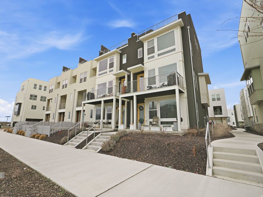 RISE above the ordinary in this exceptional four-story end-unit townhome, where light, views, and design come together beautifully. Soaring ceilings and expansive windows flood the home with natural light and frame breathtaking views of the Wasatch Front. The thoughtfully designed layout offers four spacious bedrooms - including two with private ensuite baths - creating the perfect balance of comfort and privacy. DESIGNED for both elevated entertaining and everyday living, the top-level skyroom opens to a private rooftop deck complete with a hot tub - your own personal retreat under the Utah sky. LOCATED in the heart of beloved Farmington, you're just steps from Station Park's premier shopping and dining, with a newly built city park nearby featuring pickleball courts and a way beyond average playground. Whether it's morning coffee with mountain views, starlit soaks on the rooftop, or a quick stroll to dinner, this location delivers. End unit. Two-car garage. Built in 2024. MODERN LUXURY, PERFECTLY POSITIONED.