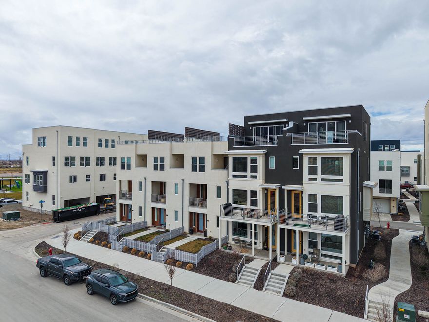RISE above the ordinary in this exceptional four-story end-unit townhome, where light, views, and design come together beautifully. Soaring ceilings and expansive windows flood the home with natural light and frame breathtaking views of the Wasatch Front. The thoughtfully designed layout offers four spacious bedrooms - including two with private ensuite baths - creating the perfect balance of comfort and privacy. DESIGNED for both elevated entertaining and everyday living, the top-level skyroom opens to a private rooftop deck complete with a hot tub - your own personal retreat under the Utah sky. LOCATED in the heart of beloved Farmington, you're just steps from Station Park's premier shopping and dining, with a newly built city park nearby featuring pickleball courts and a way beyond average playground. Whether it's morning coffee with mountain views, starlit soaks on the rooftop, or a quick stroll to dinner, this location delivers. End unit. Two-car garage. Built in 2024. MODERN LUXURY, PERFECTLY POSITIONED.