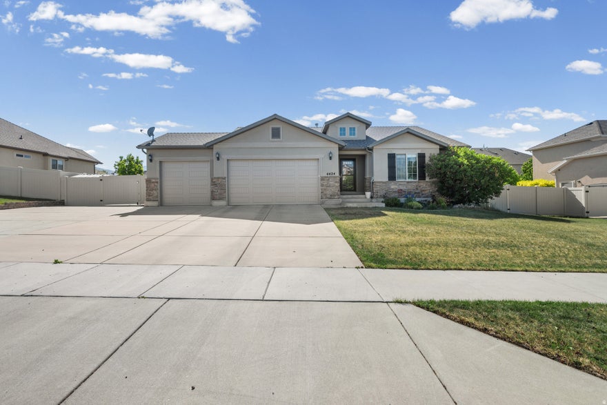 Stunning rambler with just under 3,000 square feet of beautifully finished living space - 5 bedrooms, 3.5 bathrooms, and an open floor plan split smartly across two levels. Plenty of room to spread out, host, and actually enjoy your home. Parking is no afterthought here. The oversized 3-car garage handles the daily drivers, and when that's not enough, there's secured, gated RV parking ready to go. Man gates on both sides of the house make hauling toys, tools, or trash a non-issue. Updated kitchens - yes, kitchens, plural. The main kitchen comes fully equipped with all appliances and an electric stove that's already plumbed for gas if you want to make the switch. Downstairs, the fully finished basement features a second kitchen and wet bar, also with all appliances included. Ideal for entertaining, multi-generational living, or just having your own setup away from the main level. The finishes throughout speak for themselves. Clean lines, quality materials, and the kind of details you'd expect in a much higher price point.  Tucked into one of West Valley's most convenient neighborhoods - minutes from shopping, dining, and entertainment, with quick freeway access when you need it.