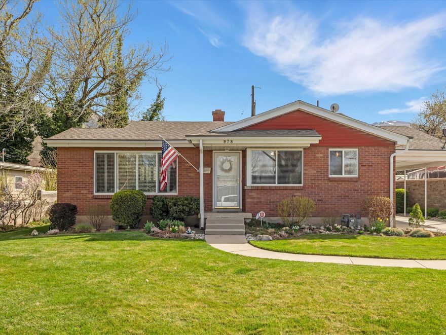 Classic charm meets exceptional care in this beautifully maintained 1950s red brick cottage, ideally situated in one of Bountiful's most desirable neighborhoods. Perfectly located near top-rated schools, parks, shopping, dining, and the South Davis Recreation Center, this home offers both timeless character and everyday convenience. Lovingly cared for and meticulously maintained by the same owner for 57 years, this residence reflects true pride of ownership at every turn. The updated kitchen features granite countertops, stainless steel appliances, a smooth top range, tile flooring, and a dining area perfect for gathering with family and friends. The well-designed floor plan offers four bedrooms and two bathrooms, along with inviting living spaces that include a bright living room, a comfortable rec room, and an expansive laundry room with abundant cabinetry that easily doubles as a craft or hobby space. Major system upgrades provide peace of mind, including a new furnace, new air conditioning, a tankless water heater, and a water softener, ensuring efficiency and comfort for years to come. Set on a beautifully landscaped .15-acre lot, the backyard feels like a private retreat with its lush lawn, mature trees, decorative water feature, manicured plantings, and solid brick privacy wall. Enjoy the convenience of a generous three-car carport and two storage sheds with power, offering outstanding flexibility and extra space. This is a rare opportunity to own a solid, lovingly maintained home that showcases classic 1950s character, modern updates, and an unbeatable Bountiful location, all in move-in ready condition.