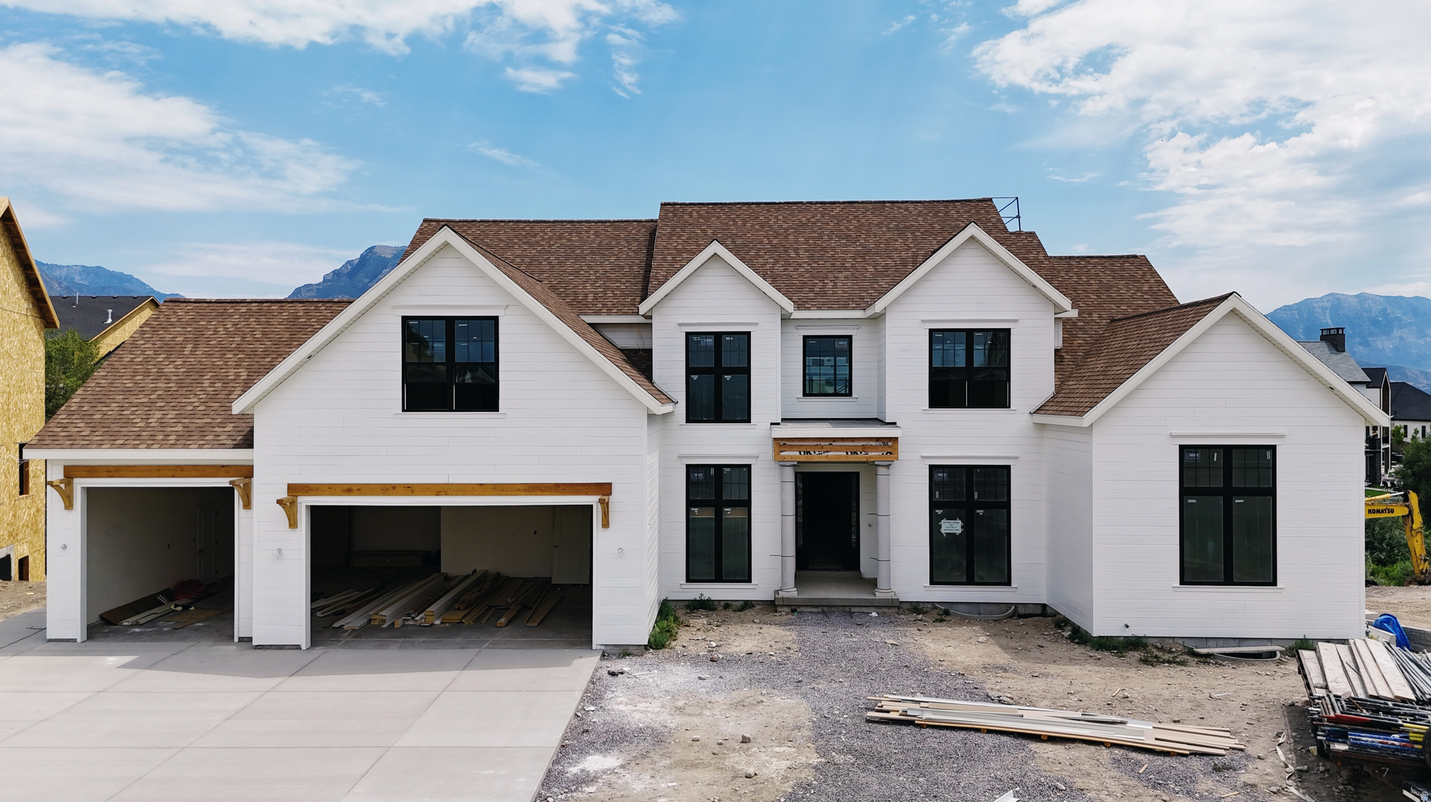 Modern farmhouse-style exterior featuring white horizontal siding and a brown shingle roof