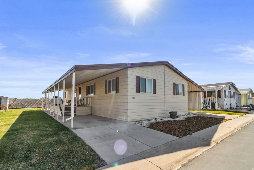 Step into this well maintained 3-bed, 2-bath mobile home, offering 1,344 sq ft of comfortable, single-level living. The home boasts vaulted ceilings in the spacious living room and a flex space/den plus breakfast nook, incredible cabinet and pantry space, and a functional layout to entertain. Wake up to stunning sunrises over the Wasatch Mountains from your covered decks and plant a few veggies in the raised garden beds!  Peace of mind comes with numerous upgrades, including a new furnace/AC as of 2015 and roof installed in 2009. The property also features a nicely landscaped yard, including an established grape vine and garden area. Located in a highly sought-after 55+ senior community, you'll have access to community amenities including a picnic area, common green space, RV parking, and on-site property management.  Square footage figures are provided as a courtesy estimate only and were obtained from building plans.  Buyer is advised to obtain an independent measurement. Agent is related to seller.