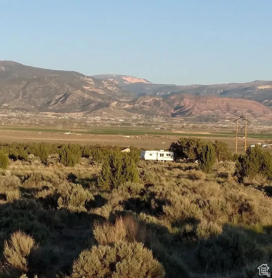 Flat buildable lot for Single Family Home + Guest house + ADU + Garage + Barn The lot has power and culinary water connections on site, 1 acre foot water share to be included with more water shares available, Fire hydrant on the property.