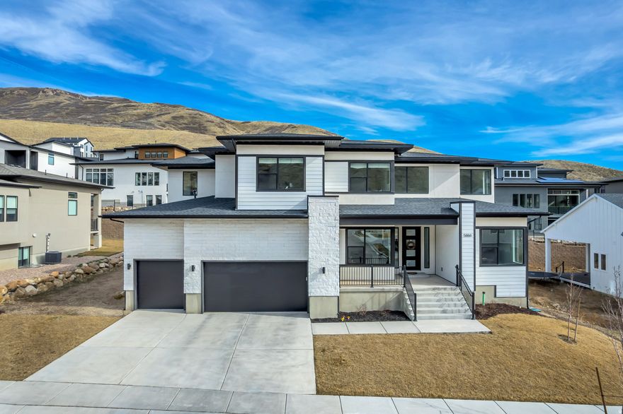 Welcome to the beautiful Canyon Point neighborhood nestled in the desirable Traverse Mountain area of Lehi! This luxurious home built by Toll Brothers effortlessly blends form and function with dramatic high ceilings and high-end finishings in a spacious, open floor plan with ample storage. The centerpiece of the property is the kitchen, featuring solid maple wood cabinetry and stainless steel JennAir appliances (induction cooktop, convection oven, microwave oven). The upgraded, oversized kitchen island is perfect for home cook and entertainer alike with stylish waterfall edges, additional cabinetry, and abundant countertop space.  Natural light abounds throughout the home, from the spacious entryway to the large primary suite, both of which feature dramatic 20-foot ceilings. In addition, the primary suite has custom-designed closet cabinetry and an extra set of laundry hookups for ultimate convenience. Large sliding glass doors in the great room lead to a covered deck and a sizable, flat yard, ideal for making the most of all areas of this home!