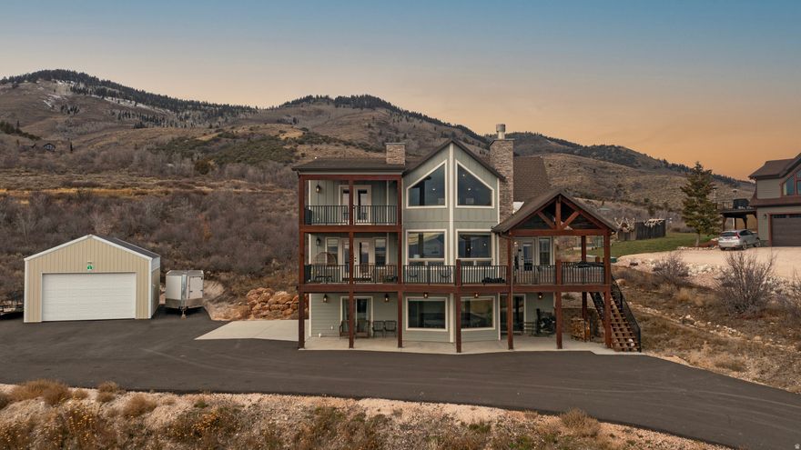 Enjoy incredible views of Bear Lake, the surrounding mountains and valley from this stunning triple-level custom home in upper Bear Lake West. The home features four extra-large bedrooms and four bathrooms, with a dramatic two-story great room on the main level showcasing expansive view windows and a beautiful rock fireplace. The great room opens onto a covered deck complete with an outdoor fireplace, while the upper level offers a covered balcony and the lower level includes a covered patio for year-round enjoyment of the scenery. The lower level also includes a spacious game room and a separate TV room, providing plenty of space for gathering and entertaining. Outside, a huge parking area and large detached garage offer ample room for vehicles, toys, and storage. As part of Bear Lake West, owners enjoy access to excellent amenities including discounted golf at the Bear Lake West Golf Course, Cooper's Restaurant and Sports Bar, an outdoor heated seasonal pool, an indoor hot tub, and private beach access to Bear Lake. Recreation surrounds you with Fish Haven Canyon just minutes away, offering miles of ATV/UTV and snowmobile trails, along with opportunities for snowshoeing, hiking, and mountain biking. Bear Lake State Park Marina is only ten minutes away, and Beaver Mountain Ski Resort is a short twenty-minute drive. Short-term rentals are not allowed by the HOA, ensuring a peaceful residential setting.