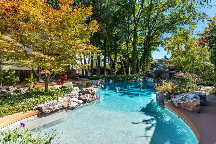Tucked away on 3.10 secluded acres, this remarkable property offers both privacy and luxury. A mature tree-lined driveway leads to a beautifully landscaped oasis featuring a courtyard-style backyard, custom pool with spa-like ambiance, and an in-ground hot tub and waterfall. Inside, vaulted ceilings and a thoughtfully designed floor plan create an inviting atmosphere. The gourmet kitchen is complemented by a screened-in patio with an outdoor grill and wet bar perfect for entertaining. The main-floor master retreat offers direct access to the pool and spa, creating the ultimate private escape. Additional amenities include a large home gym, outdoor fireplace and patio, firepit, horseshoe and shuffleboard areas, basketball standard, and expansive parking for all your toys and equipment. A detached oversized garage and workshop, is fully equipped with everything you could need including 220v power, a dust collection system, office and half bath. In addition to the workshop you'll find a 3-bedroom, 2-bathroom, accessory apartment providing the perfect guest retreat or potential rental income. Reach out today to make this property with endless opportunity, your own. Buyer/Buyer's Agent to verify all info.