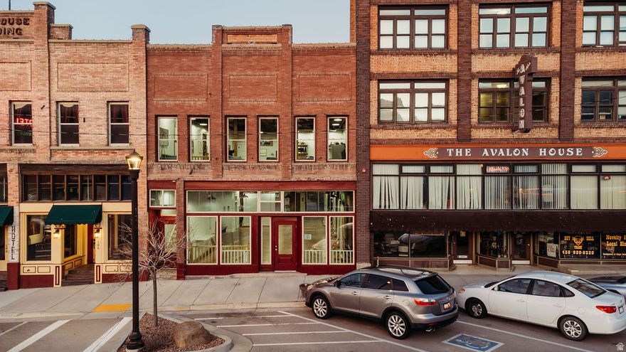 Discover this beautifully restored tri-level building on historic Helper Main Street, where thoughtful artistry meets modern functionality. This fully renovated space preserves its rich history, ensuring each detail reflects both sophistication and intention.  The main level offers over 3,000 square feet of open space, showcasing original red douglas fir flooring, 20-foot ceilings, a private bathroom, and front and back entrances, making it ideal for a gallery or retail space.  Above, the living quarters feature a private entrance, a loft-style living area and stunning views. This level includes five skylights, three bathrooms, four bedrooms-two of which are en suites. Enjoy the balcony off the primary bedroom and private entrance facing the Price River and views of balance rock. All countertops throughout are hand crafted from the building's reclaimed materials. You'll also find ample gallery walls perfect for displaying art. Additionally, there is the convenience of a laundry room.  The lower level, with its own entrance, includes a kitchen, laundry, 3/4 bath, and plenty of open space inviting your creativity.  This historic building has all-new electrical and plumbing systems, along with modern windows, lighting, and new roof. Each floor is thoughtfully zoned with its own air conditioning and heating units, ensuring both comfort and efficiency throughout the property.  Enjoy sweeping views of the Book Cliffs and the nearby river.. This versatile space serves as an inspired studio, gallery, and  unique living area, where every corner tells a story.   Square footage figures are provided as a courtesy estimate only and were obtained from County Records. Buyer is advised to obtain an independent measurement.