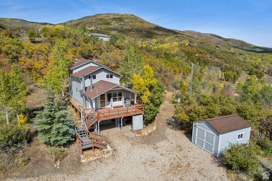 Perched atop 2.3 pristine acres just east of Oakley, this stunning 2,220 square foot cabin offers breathtaking "top of the world" views from every angle. Wake up to sunrise over Thousand Peaks Ranch from your east-facing deck, then end each day watching spectacular sunsets paint the Wasatch Back from your front porch. The thoughtfully designed outdoor space features secluded fire pits and terraced yards perfect for children's play, all nestled in complete privacy. Inside, you'll discover a spacious layout with two inviting living areas, each anchored by its own cozy wood-burning stove, while the well-appointed kitchen with stunning down-canyon views seamlessly connects both living spaces. The cabin features three comfortable bedrooms- one on the main floor and two lofted for maximum privacy-plus one full bathroom. The unfinished basement presents endless possibilities, already plumbed for an additional bathroom with framing and electrical work partially complete, and with its own entrance and independent heating source, it's ready for your vision. Located in the seasonally accessible Beaver Springs Ranch community, you'll enjoy Weber River access and limitless outdoor adventures, with Smith and Morehouse Reservoir and National Forest lands just moments away, putting world-class recreation right at your doorstep.   Square footage figures are provided as a courtesy estimate only.  Buyer is advised to obtain an independent measurement.