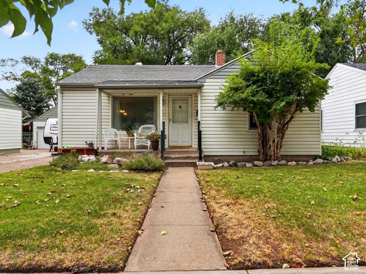 Traditional residence featuring white horizontal siding, a covered front entry, and a concrete pathway
