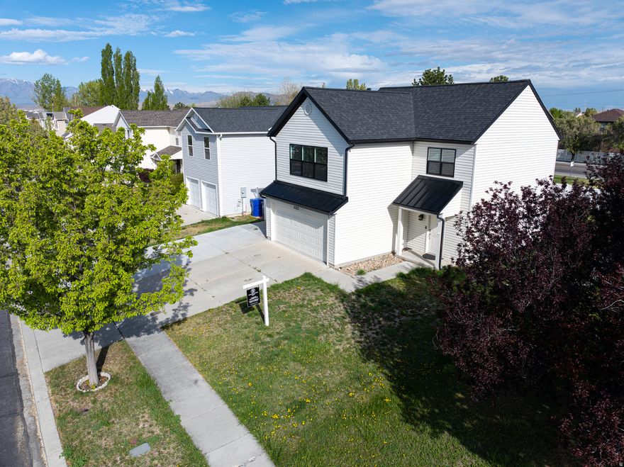 Perfect for a summer block party hangout, workshop, or an ideal space for classic car enthusiasts, this Saratoga Springs, Utah Lake property features an additional 25' x 25' detached garage, The garage is fully insulated and temperature-controlled with both heating and cooling. It's also great for toy storage or hobby use.  Beautifully remodeled from top to bottom, this home offers no HOA and no rental restrictions, an excellent opportunity for homeowners and investors alike.  The exterior showcases striking curb appeal with a brand-new roof, modern metal eave accents, black gutters, contemporary black windows, new metal siding, and a stylish new front door.  Inside, every detail has been thoughtfully upgraded. Luxury plank flooring and fresh designer paint create a clean, modern feel throughout. The chef-inspired kitchen serves as the centerpiece, featuring white shaker cabinetry, quartz countertops with a dramatic waterfall edge, a custom panel-front refrigerator and dishwasher, and a sleek single-basin stainless steel sink with a pull-down faucet. A reverse osmosis system with remineralization adds everyday convenience.  Smart home features include smart light switches, thermostat control, smart garage door openers, ceiling fans in every room, Ring security cameras, and energy-efficient recessed LED lighting. A new water heater and water softener enhance comfort and efficiency.  Two additional guest bedrooms provide comfortable accommodations one with a walk-in closet alongside a beautifully designed bathroom with shiplap accents, modern fixtures, and warm white oak cabinetry.  The home offers an abundance of storage with finished attic space above the detached secondary garage.   In addition, the home includes an oversized attached two-car garage and a dedicated parking pad for RV or boat storage, providing ample space for all your vehicles and recreational needs.  Located near Utah Lake in one of Saratoga Springs' most desirable neighborhoods, with many parks, walking trails and a top-rated elementary school nearby, this lake home offers the perfect balance of luxury finishes, smart technology, and lifestyle flexibility.