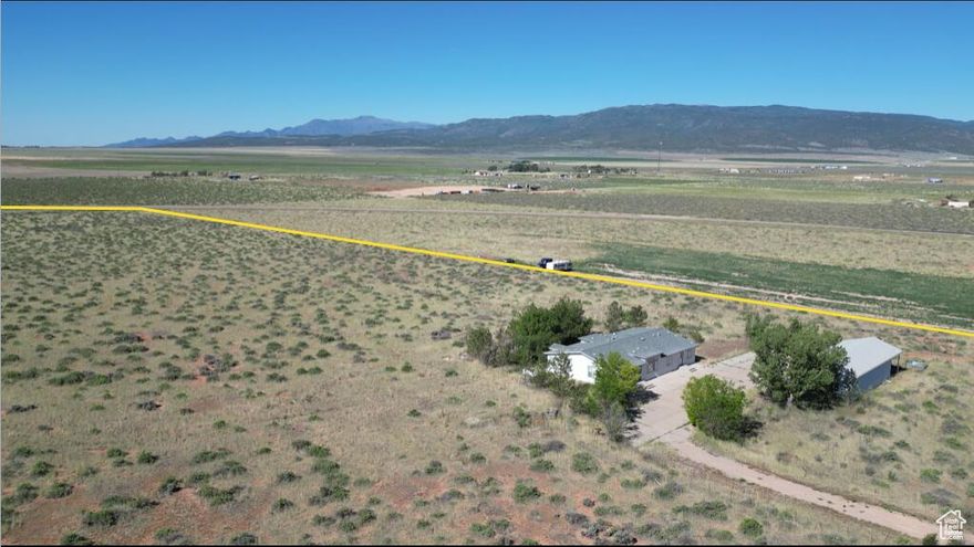 Almost 20 acres with 4 car garage/workshop with opener and attached high carport, and a 5 bedroom manufactured home that can be converted to an office. Property is in process of being re-zoned commercial. Close to I-15. Property has 1 acre foot of underground water #73-3142 in existing private well. Home was recently repainted inside and out; new flooring installed throughout the home; re-shingled; new A/C (forced air). Detached garage to be repainted inside.