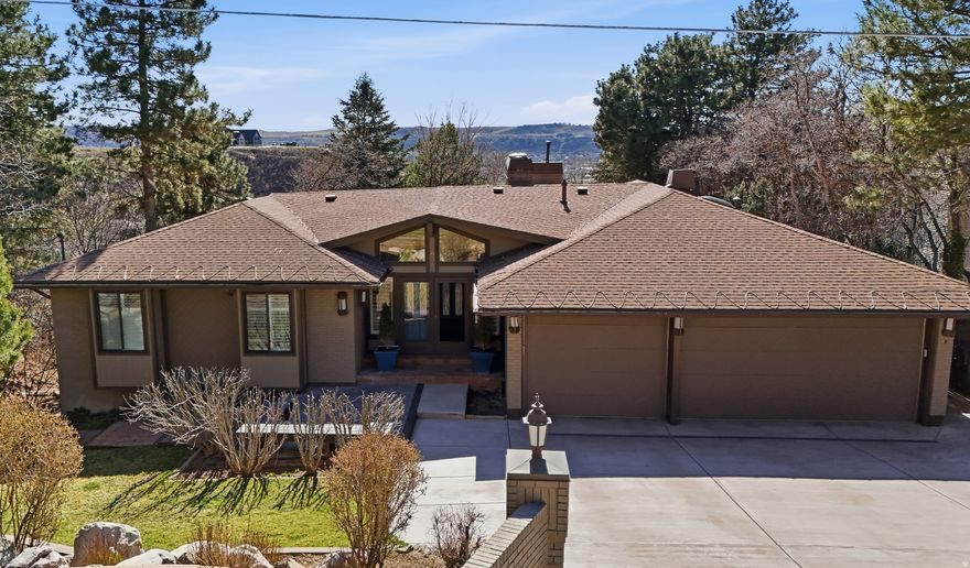 Welcome to 6313 Bybee Dr! Located in a highly desirable Ogden neighborhood, this beautifully maintained 4 bedroom, 3 bathroom home offers privacy, views, and well-designed living spaces. Set on a secluded lot with a cozy, established yard, the property features a spacious 3-car garage and a custom chef's kitchen that serves as the heart of the home. The kitchen is designed for both everyday living and entertaining, featuring two dishwashers, two cooktops, two ovens, two pantries, a large island, high-end appliances, and a range hood, along with a generous dining area and direct balcony access. All four refrigerators are included with the house. Built-in sound speakers enhance the kitchen and family room area, with additional speakers installed on the deck for seamless indoor-outdoor entertaining. Inside, updated hardwood flooring, upgraded windows, and abundant natural light create a comfortable and inviting atmosphere. The main level includes two bedrooms and two full bathrooms, a spacious primary suite with a walk-in closet, cozy sunroom/sitting area and direct access to the incredible deck. The primary bath features a large standalone shower, separate soaking tub, and double vanity. The additional upper bedroom includes a built-in dresser that will remain. A see-through wood-burning fireplace adds character to the main living space, while custom shades enhance comfort throughout. The fully finished basement provides flexible additional living space with two oversized bedrooms, a bathroom with double vanity and  shower, kitchenette, laundry and a dedicated food storage room. The theater area includes surround sound, soundproofing, projector, and screen (projector requires a new bulb). A spacious private office with built-in shelving overlooks the yard, and an additional craft room/den adds versatility. Two gas fireplaces add warmth to the lower level. Two 50-gallon water heaters, separate furnaces for each level, and additional heat sources in each bathroom provide year-round comfort. The 3-car garage features epoxy floors, built-in lockers, attic storage, a warm-water hose bib, a built-in Viking refrigerator, an additional refrigerator that will remain, and an additional shed/storage area just outside the garage. In the backyard there are two large sheds with electric power. Outdoor living is private and functional, a fenced yard featuring mature landscaping, grass areas, a play gym, multiple balconies and deck spaces, and a reinforced deck designed to support a hot tub. The property also includes a heated driveway, roof heat tape, auto sprinklers, and additional parking. This home is truly one of a kind: schedule your private showing today!