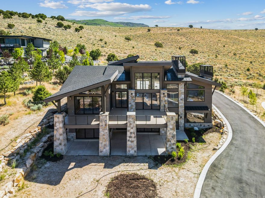 Experience luxury mountain living at its finest in this brand-new 6,500 sq ft contemporary masterpiece, ideally situated in the prestigious gated community of Red Ledges. Showcasing panoramic views of the Heber Valley and surrounding mountain range, this light and bright home is designed to impress. Featuring 5 spacious bedrooms, an expansive great room, and an impeccably designed kitchen with double islands. Downstairs has plenty of space for entertaining, with a gym and theatre room, every inch of this home blends modern elegance with mountain charm.