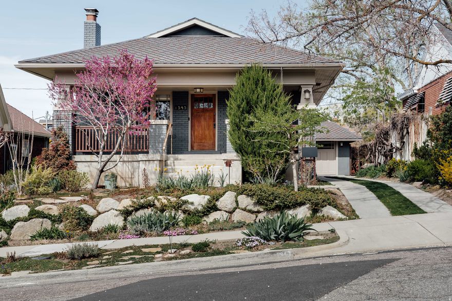 Embrace the quintessential Salt Lake lifestyle in this enchanting 1914 Arts & Crafts bungalow showcasing stunning period character and ideally positioned on a tree lined street with mountain views within one of Salt Lake's most sought after historic neighborhoods.  An inviting covered front porch creates the vibe before you step inside to a thoughtfully updated interior that beautifully preserves its original Craftsman details, including the Batchelder tiled fireplace, built-in cabinets with stained glass doors, coffered ceiling, and oak hardwood floors. Rich in character, the open living and dining areas feel simultaneously cozy and airy, ideal for everyday living and effortless entertaining. A fully finished basement elevates the home's value, enhances its functionality, and seamlessly expands the total living space. Outside, a rear patio and sun-drenched garden with mature fruit trees, and glorious perennial gardens give the feel of year-round country living, offering a tranquil retreat or the setting for dining al fresco. Custom metal gates, trellis and porch railings as well as imprinted artistic touches in the poured concrete on the front patio and back entrances are notable and unique. Extra width two-car tandem garage has 2 separate storage rooms off the back as well as attic storage. Within a few blocks, enjoy a selection of eateries, a quaint bookstore, an art gallery & convenient transportation at 15th & 15th. Also, near neighborhood market and schools.