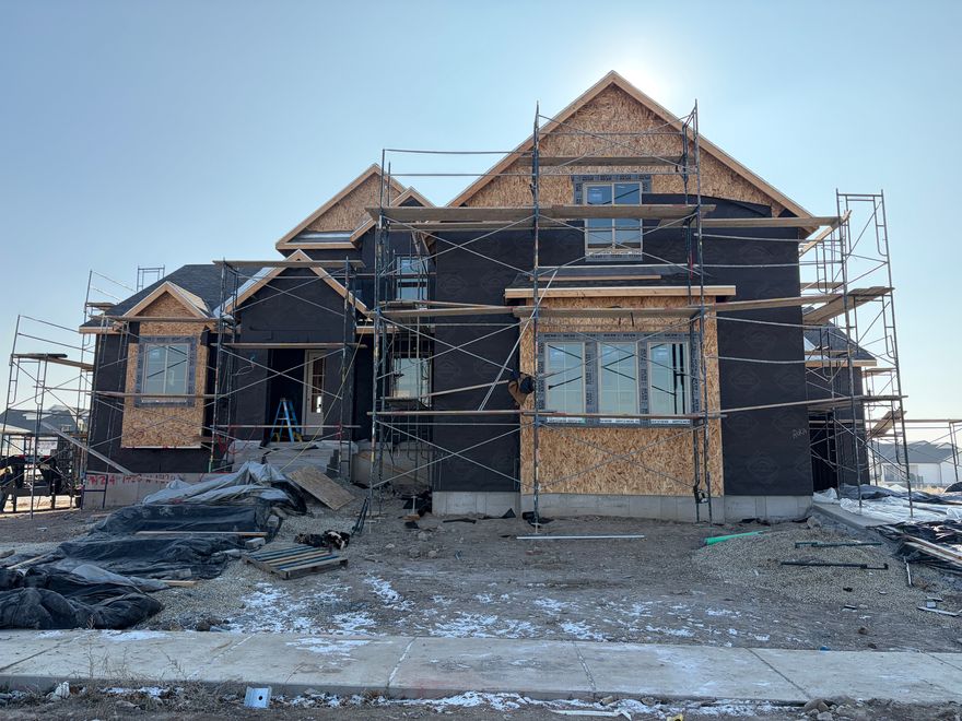 Thoughtfully designed for both style and livability, this brand new custom home in Lehi offers 5 bedrooms, 3.5 bathrooms, and refined finishes throughout. Situated on a generous 1/3 acre lot, the home provides space, natural light, and intentional design in a sought after neighborhood with no HOA. At the heart of the home is a beautifully appointed kitchen featuring tailored cabinetry, a statement range hood, a walk through pantry with dual entry, a Forno 8 burner gas range, and full size refrigerator and freezer. Two story living room ceilings and expansive windows fill the home with natural light. Step outside to the covered deck overlooking the spacious backyard, creating an ideal setting for both everyday living and entertaining. The main level primary suite offers an upscale private retreat with a freestanding soaking tub, oversized shower, and walk in closet. Upstairs includes four additional bedrooms, a playroom, two full bathrooms, and a second full laundry room, with a convenient Jack and Jill layout between two bedrooms. The basement is designed for easy future completion and can be finished as an ADU. A three car garage provides ample parking and storage. Ideally located near shopping, dining, schools, and the Silicon Slopes corridor. Photos are for illustrative purposes only and may not reflect the exact home. Estimated completion: March 2026.