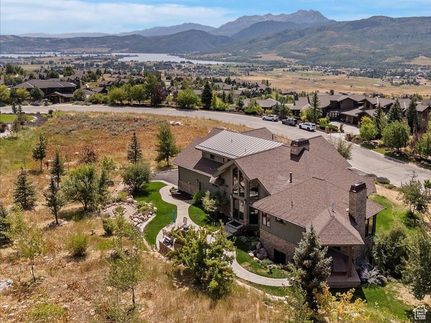 Experience breathtaking lake and mountain views from this custom-built 4,452 sq ft luxury retreat in The Highlands at Wolf Creek. Only a few residences in The Highlands can boast about the unparalleled views from every room in this custom residence build with superior craftmanship by Buxton Builders in 2007. Our stunning listing features soaring ceilings and arches, custom Pela windows throughout and every door is stunning custom Alder wood with solid wood trim and custom arches. Enjoy a Modern styled wrap-around covered deck for summer and winter enjoyment   Picture yourself savoring sunset views from the deck after a day boating on Pineview or unwinding by the outdoor fireplace and cookery after carving fresh powder at Snowbasin or Powder Mountain. Views of Snowbasin, Nordic Valley, Pineview, Ben Lomond Peak of the Wasatch Back, and the Ogden Valley.The open-concept living, dining, and gourmet kitchen is welcoming with its cathedral ceilings, a custom hand-blown glass chandelier, a dramatic floor-to-ceiling stone fireplace, custom Alder wood cabinetry, granite countertops, and Wolf appliances. The main-level primary suite features its own stone fireplace, spa-inspired bath with soaking tub, and a sauna. Upstairs, you'll find a second en-suite primary, plus a private study with custom floor-to-ceiling cabinetry. Luxury finishes include walnut floors, handmade 10-foot doors, and custom lighting throughout. The lower level offers two additional bedrooms, a large 3/4 bathroom, a theater room with velvet curtains and leather seating, new HD projector, Sonos surround sound, and a cozy fireplace-plus space for a pool table or game area.  The radiant heat flooring keeps it warm in the winter and even without air conditioning, the lower-level stays cool during the summer months. Enjoy year-round outdoor living on the expansive patio with built-in grill, stone fireplace, and private hot tub. A heated 3-car garage with storage, meticulously landscaped .88-acre lot, pre-listing inspection, and option to purchase two additional lots make this an exceptional mountain home.