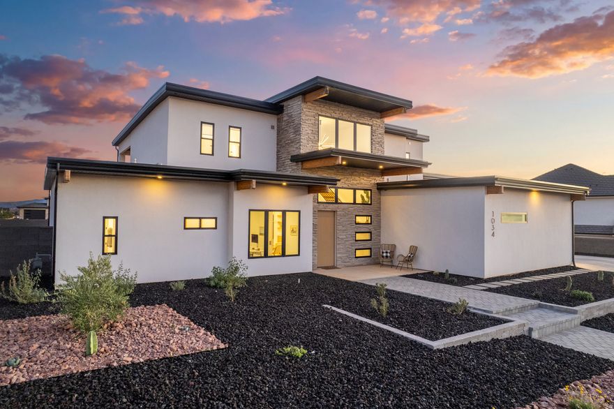 This pristine home in the Rusted Hills Subdivision was completed just four years ago and features four bedrooms plus a private office. Built with 2x6 construction, spray foam roof insulation, and insulated interior walls and floors, the residence offers exceptional efficiency and privacy. The interior features 10' ceilings on the main floor and 9' ceilings on the second floor, complemented by tall doors, a mudroom, a bonus loft, and a double-insulated office. High-performance systems are in place, including Ethernet fiber internet, a water softener, two HVAC units, and two water heaters (one gas, one electric).  Outdoor amenities include a heated saltwater pool controllable via a smartphone app, an electric awning, and a fully fenced yard with a gas stub for a future outdoor kitchen. The front yard is pre-plumbed for a water feature. For storage, the property provides an extra-deep RV garage, RV parking, and an EV charger, all powered by low-rate Dixie Power.  Located on a quiet cul-de-sac, the home is within walking distance of Majestic Fields Elementary, the new Wheels Park, and a bike path to Washington Dam Road. It is zoned for Crimson High School and offers quick access to the new George Washington exit and the upcoming Star Nursery, while remaining outside the airport flight path. With BLM land and Warner Valley nearby, you can enjoy unobstructed red rock views and desert adventure directly from home.