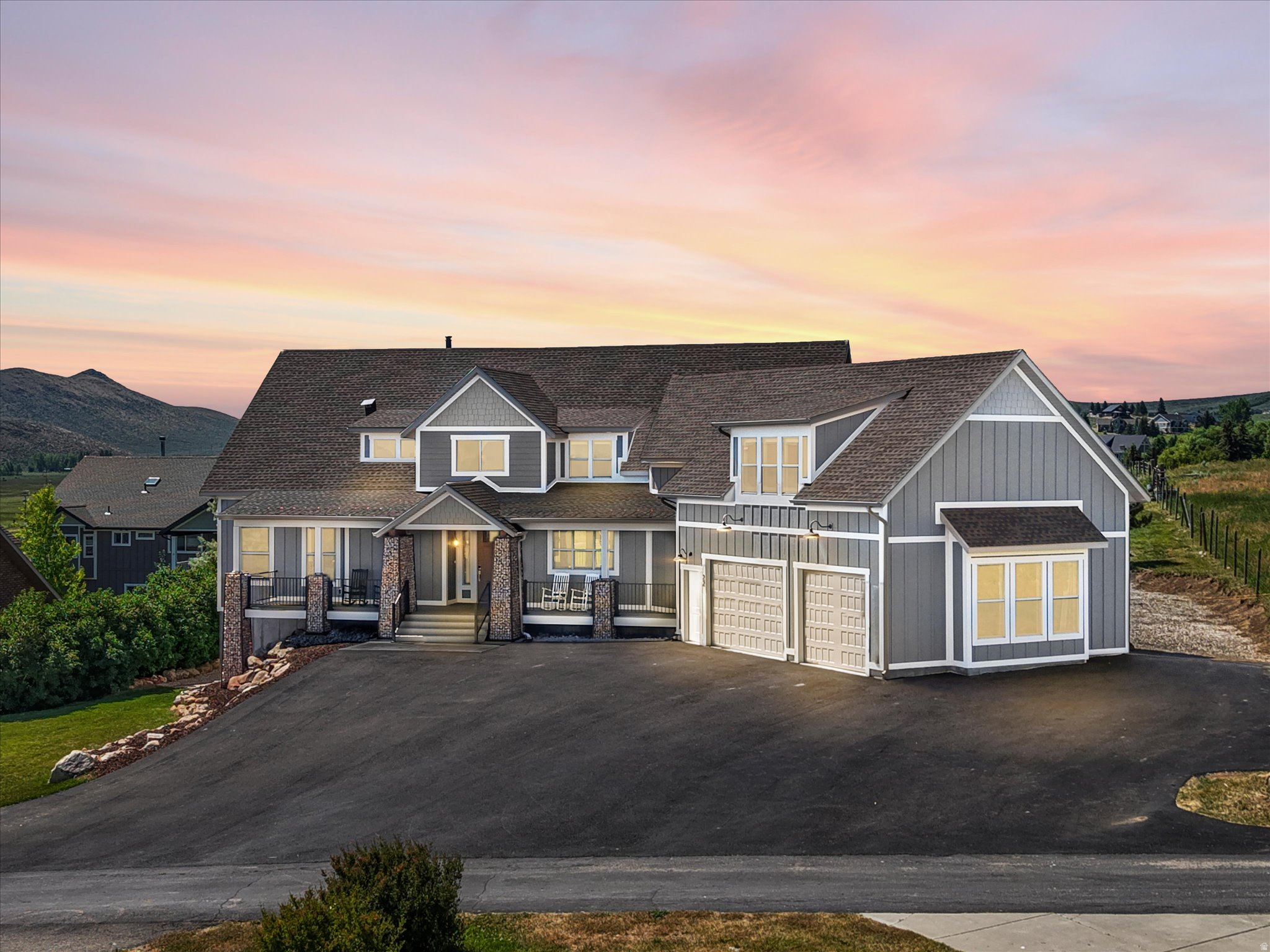 Modern gray siding exterior with multiple gables and a stone accent foundation