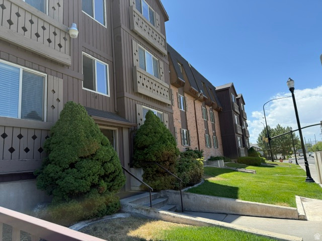 Multi-story building exterior featuring brown siding and brick accents