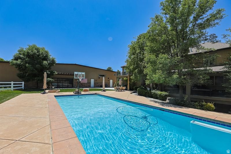 Sparkling resort-style swimming pool with crystal-clear water and sun deck featuring stamped concrete decking