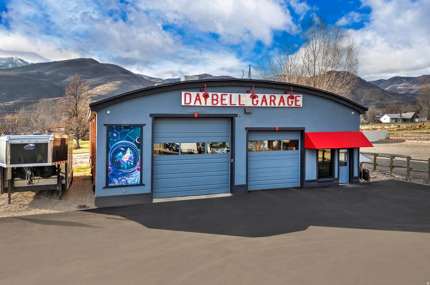 Daybell Garage is an iconic, restored, corner commercial building in Midway's walkable downtown C2/C3 District. The listing features two lots totaling  acre with myriad permitted uses-office, retail, multi-unit residential, short-term rentals, and more. All public utilities connected.  The 3,333 SF main structure (2025 restoration) delivers a motor enthusiast's dreamscape: authentic automotive art, multi-vehicle capacity, lofted office, a full suite of SONIC tools and cabinets, lounge bar, kitchenette,  bath, wash/vacuum stations, and premium integrated security, lighting & sound system. A vintage grain silo, a 359 SF storage shed, and a new, air-flow-regulated 45' shipping container offer extra space. A rare 1986 Porsche 911 Targa Widebody (M491) is also included at the asking price.  This is an amazing (and fun) opportunity to own a bookend to one of the quickest emerging, desirable commercial corridors in the Intermountain West. Don't miss out!