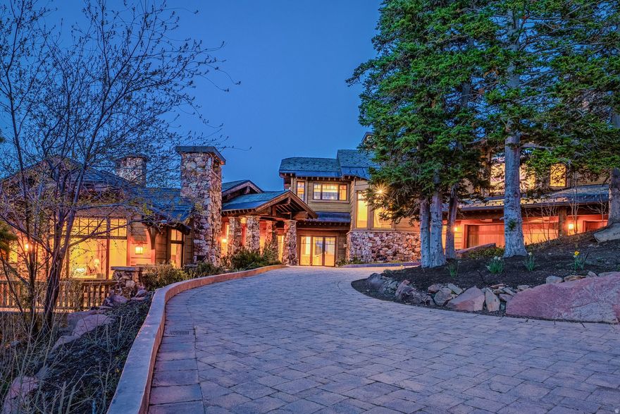 Located within the exclusive gated community of The Colony at White Pine Canyon, this extraordinary ski-in/ski-out mountain estate, with private guest house, offers expansive panoramic views stretching across the surrounding mountain ranges and valleys. Positioned on 6.13 secluded acres surrounded by mature trees and alpine landscape, the property blends privacy, luxury, and year-round adventure in one of Park City's most coveted mountain settings. Designed as both a refined retreat and gathering place, this property features 8 total bedrooms and 10 bathrooms thoughtfully distributed across the main residence, a private guest house, and a separate mother-in-law apartment - creating exceptional accommodations for family and guests alike. Warm mountain finishes, expansive gathering spaces, and thoughtful design create a welcoming atmosphere throughout the home. The heart of the residence centers around the kitchen, dining areas, and great room, seamlessly connecting indoor and outdoor living spaces. Elegant amenities include formal dining, multiple wood-burning fireplaces, a heated outdoor patio with fireplace and hot tub, theatre, private office, wine room, game and recreation spaces, and a custom bar designed for effortless entertaining. With direct ski-in/ski-out access from the Twilight ski run at Canyons Resort, adventure begins directly from your door. The dedicated ski room is thoughtfully designed for convenience and organization, while surrounding trails offer endless hiking and biking opportunities during the summer months. Whether skiing fresh powder, exploring mountain trails, soaking in the hot tub beneath alpine skies, or relaxing fireside after a day outdoors, the home is every aspect of the Park City mountain lifestyle. Additional features include garage space for five vehicles, three laundry areas, a heated driveway, expansive patios, and a grand circular drive - all balancing comfort, functionality, and elevated mountain living. Residents of The Colony enjoy direct access to world-class recreation and a soon to be completed homeowner clubhouse, creating one of the most exclusive and connected mountain communities in Park City.