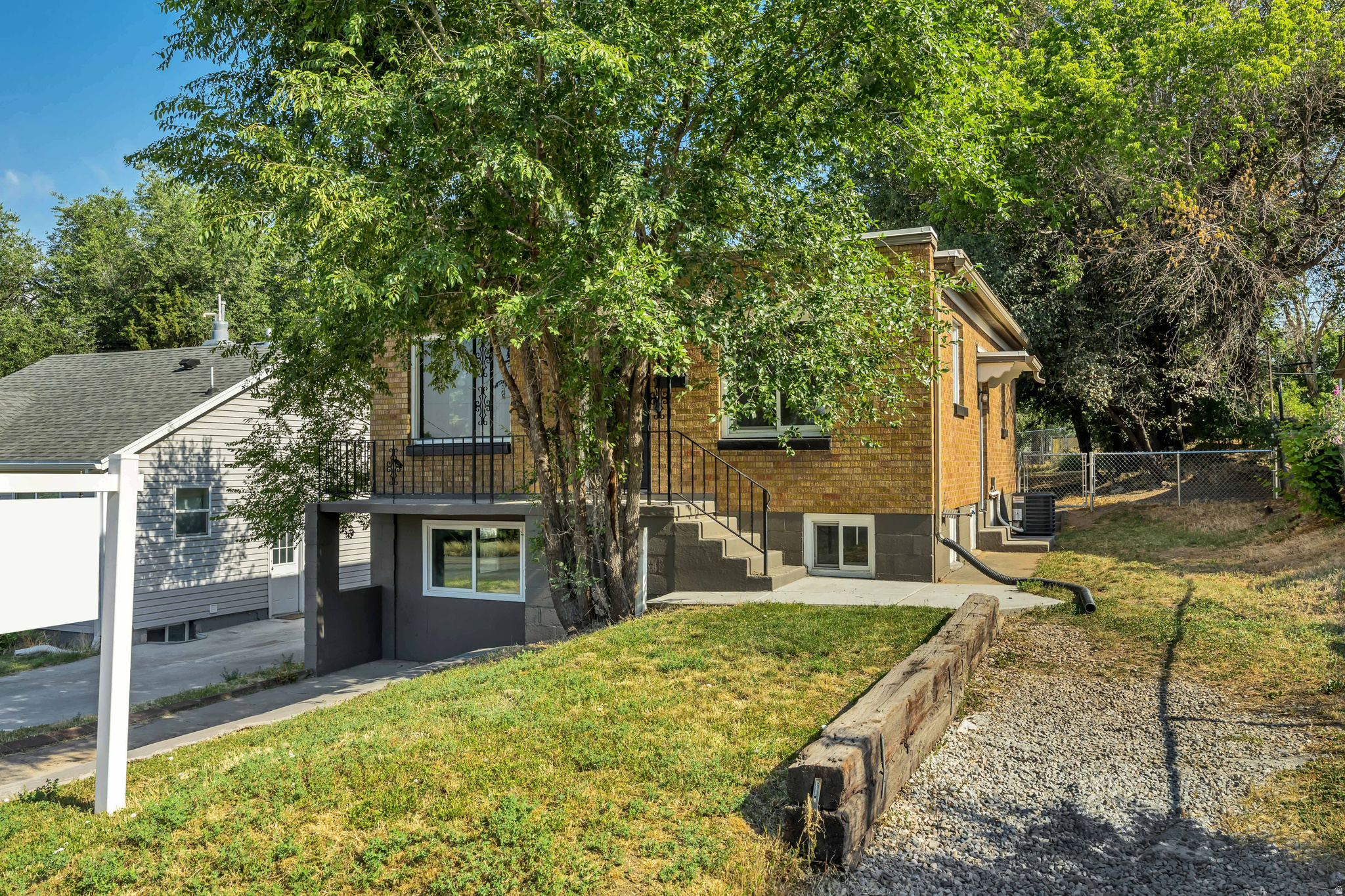 Two-story property featuring a brick exterior and a ground-level entrance with a balcony above