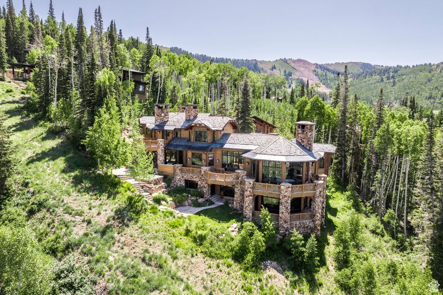 Set within the private, gated community of The Colony at White Pine Canyon, this remarkable ski-in/ski-out estate offers some of the largest and most unobstructed views of the mountains, basin and Park City area.  Positioned on 6.13 secluded acres surrounded by mature trees, the residence combines refined design with a warm, inviting atmosphere. The home features 8 bedrooms, 10 bathrooms, a private guest house, and a separate mother-in-law apartment, providing generous space for family and guests. The main living areas-anchored by the kitchen, dining spaces, and great room-are thoughtfully designed for gathering and connection, creating a comfortable flow throughout the home. Elegant mountain details include a formal dining area, wood-burning fireplaces, heated patio with fireplace, a dedicated ski room, theatre, private office, wine room, and a second living room with a game area. The main living room features a custom bar and opens seamlessly to the outdoor patio, creating the perfect setting for entertaining and relaxation.  With ski-in/ski-out access from the Twilight ski run of the Canyons Resort, this home is well equipped for adventure seekers.  The private ski room is thoughtfully designed and well organized, offering the perfect place to store and prepare gear for a day on the slopes.  With three laundry areas, garage space for five vehicles, a heated driveway, and expansive patios and circular drive - this home is convenient - balancing privacy, luxury, and access.  The Colony offers direct access to skiing, hiking, and biking, along with a stunning new homeowner clubhouse - a vibrant gathering place to connect, relax, and enjoy the spirit of this exclusive mountain community.