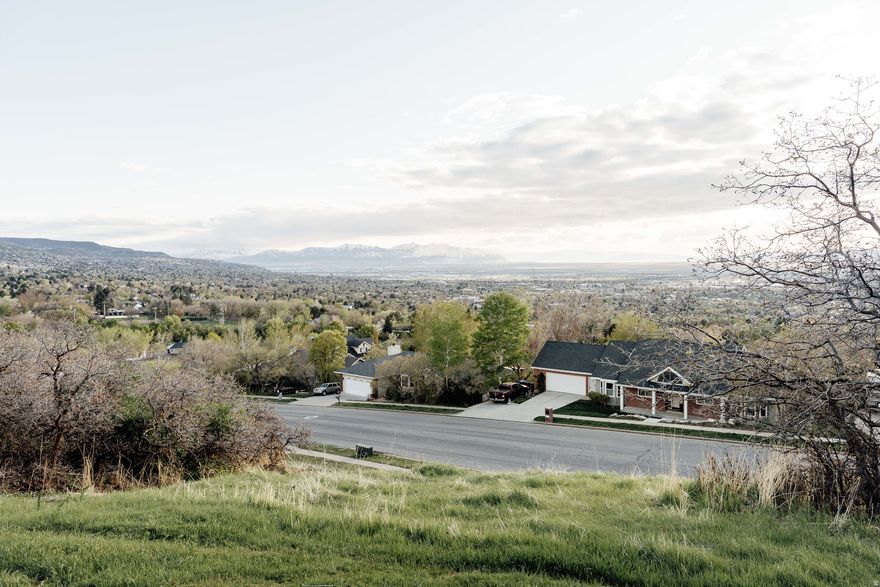 Perched high on Bountiful's coveted East Bench in the quiet Quailbrook neighborhood, this .29-acre homesite has sprawling views that encompass the valley below, the mountains beyond, and the glimmering Great Salt Lake in between. Despite the peaceful setting, you're just minutes to Bountiful's downtown amenities, or a quick commute to Salt Lake City and the airport. Bring your own creative vision to this lot, or utilize existing modern build plans specifically designed for this parcel by Urban Home, a design-build firm with a passion for minimal, compelling architecture. Utilities are stubbed and included plans have been stamped by engineers. If modern design is your thing, the proposed build plan utilizes simple materials-concrete, wood, glass and steel-with a minimal design that also values livability, function and comfort. Seemingly simple, it's supported by complex engineering and architectural creativity. Modern features include a floating fireplace, clerestory windows, movable shade panels for optimal light filtering and thermal gains, a wrap-around deck, an open floor plan and more. Intentionally designed with this lot's unique topography and natural light path in mind, the build orientation also maximizes the incredible sunset views. Purchase the dream for under $300k and then let Urban Home turn it into a reality....