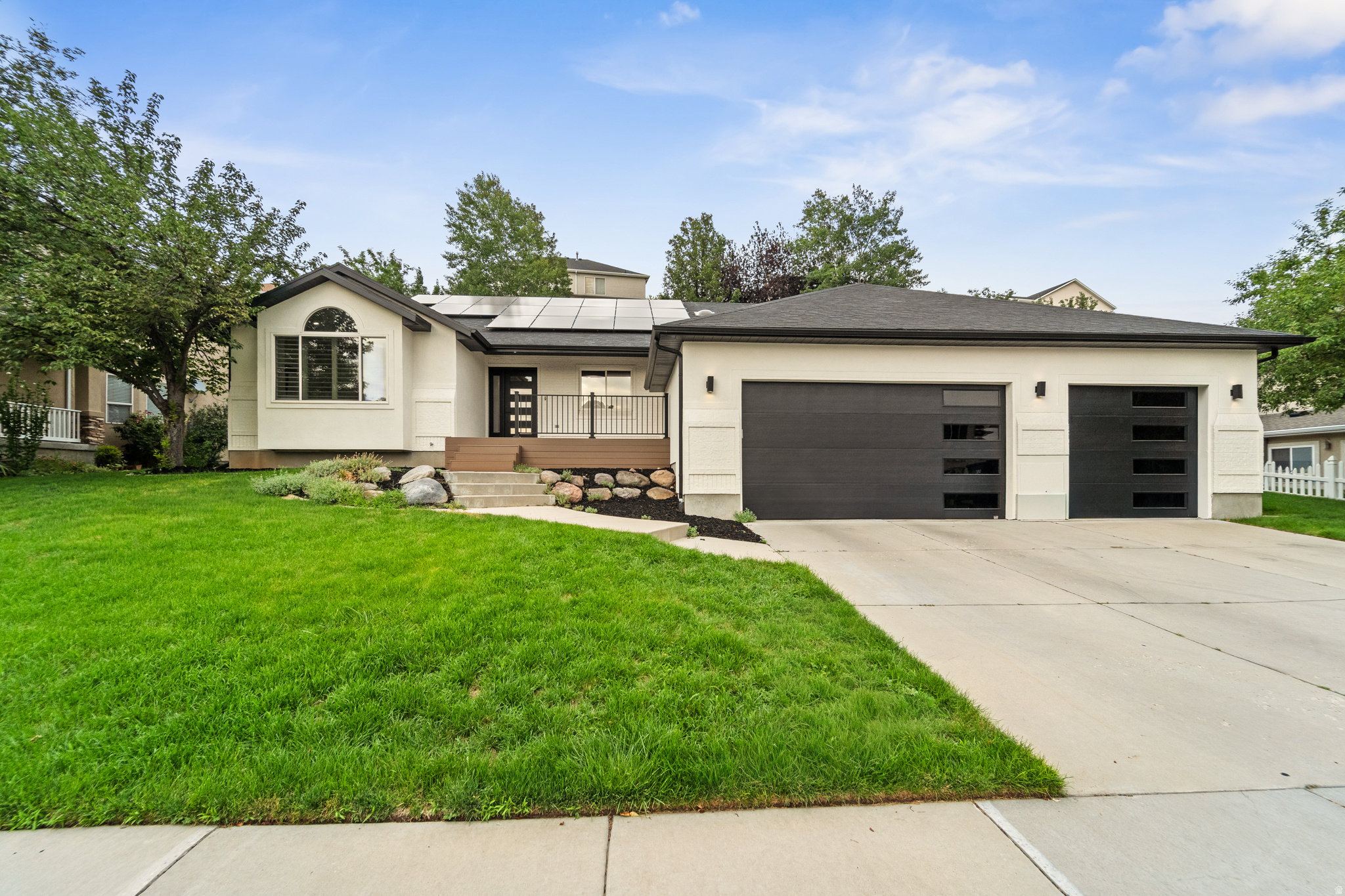 Contemporary-style exterior with a two-car garage featuring modern dark doors