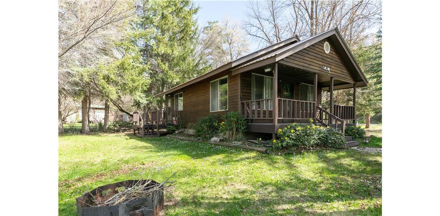 RIVER FRONTAGE! Escape to nature with this charming 1-bedroom/1-bath RIVERFRONT cabin nestled along the Cub River in a beautifully wooded setting. Designed for recreational use, this cozy retreat offers the perfect place to unplug and unwind while enjoying the sights and sounds of the river just steps away. Inside, you'll find granite countertops, durable LVP flooring throughout, an on-demand water heater, and a warm propane fireplace for year-round comfort. Ideal for weekend getaways, or a peaceful basecamp for outdoor adventures, this property delivers rustic charm with modern finishes in an unbeatable natural setting. 2 RV hookups on electrical panel available.