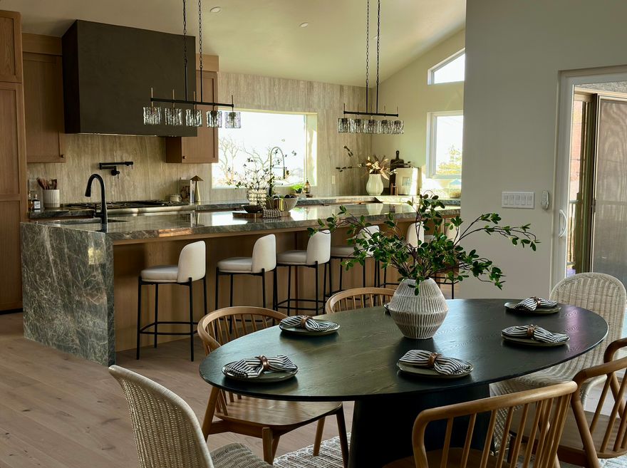 Experience elevated living in this one-of-a-kind home, ideally located in Salt Lake's prestigious St. Mary's neighborhood on the East Bench. 2551 E Sherwood Drive offers nearly 6,000 square feet of refined design, seamless flow, and attention to detail. This home is a rare offering where comfort, and location come together to create something truly special. The open living spaces are anchored by a show-stopping chef's kitchen featuring a 14-foot waterfall quartzite island, custom white oak cabinetry, and fully paneled Thermador appliances, including a 60-inch refrigerator/freezer, custom oversized pantry cabinets and dual  dishwashers. From the kitchen and adjacent covered patio, sweeping views of the Salt Lake City skyline and Capitol unfold, with the patio adding stunning mountain vistas-perfect for quiet mornings or evening gatherings. A wraparound deck connects the kitchen and patio, inviting you to take in the scenery from every angle. With five bedrooms (four of which with dedicated ensuites) and six bathrooms-this home offers exceptional privacy and comfort. Additionally, if preferred, the office could easily be converted to a 3rd main floor bedroom. The primary suite is a true retreat with waterfall shower head, dual wall shower heads/hand wands, a spa bath, and a true walk-in closet with private laundry hookups. Two additional laundry areas provide everyday ease, one providing plenty of space for multi functionality, craft/mudroom. The daylight walk out basement with separate entrance from the lower 2 car garage opens to a massive great room ideal for entertaining, game nights, rec room, and/or gym.The family room sets the tone with a beautifully plastered gas fireplace and dedicated entertainment closet. A second full kitchen, dining area, exceptionally spacious secondary Primary bedroom with lots of natural lighting throughout make this perfect for guests or multi-generational living.  Outside, the resort-style, low maintenance Xeriscaped yard with heated pool, gazebo, and gas firepit is a private escape. Three attached garages with epoxy floors-including EV charging in the lower 2 car garage. The single car garage provides entrance to the main floor office for privacy. This home is genuinely turn key with close proximity to downtown, the University of Utah, world-class hiking and biking trails, and some of the city's best dining and culture. The setting is peaceful yet connected-an ideal balance of privacy and lifestyle. Don't miss the opportunity to make this exceptional property your own! Contact us today to schedule a private showing!